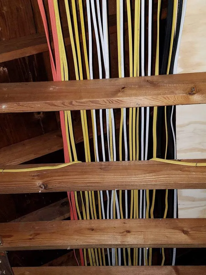 Electrical cable run through open ceiling joists before drywall